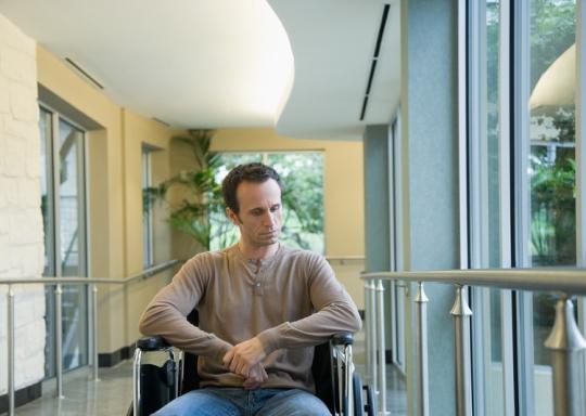 White male wheelchair user. He has a depressed expression