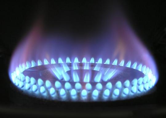 Image shows burning blue gas ring on a black background