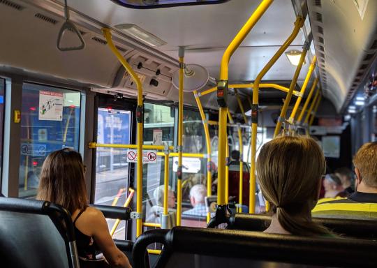 Image of passengers sitting on the inside of a bus