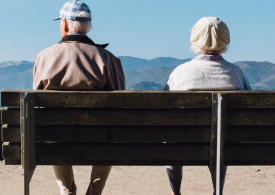 2 old people sitting on a bench