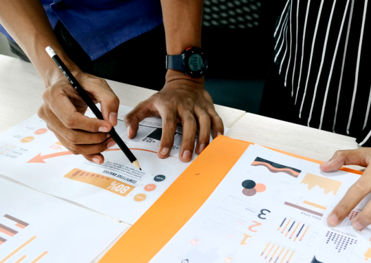 image of two people writing on a table, for research