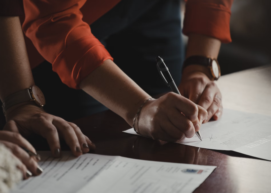 two people reviewing documents on a table