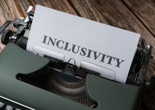 image of a grey typewriter with paper inserted saying: inclusivity 