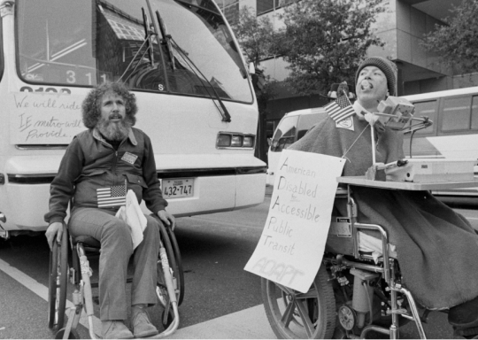 image of two wheelchair users blocking a bus in america in the 60s