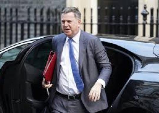 Image shows MP Mel Stride exiting a black car holding a red folder.
