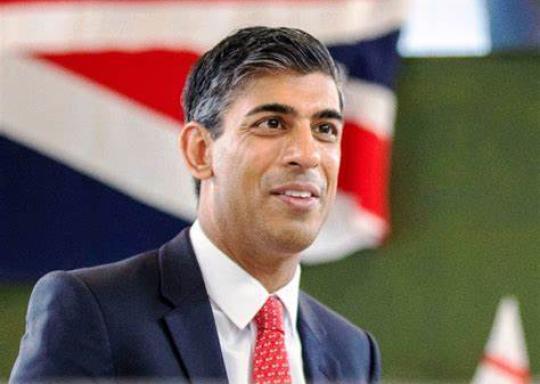 image shows a smiling Rishi Sunak in front of a union jack