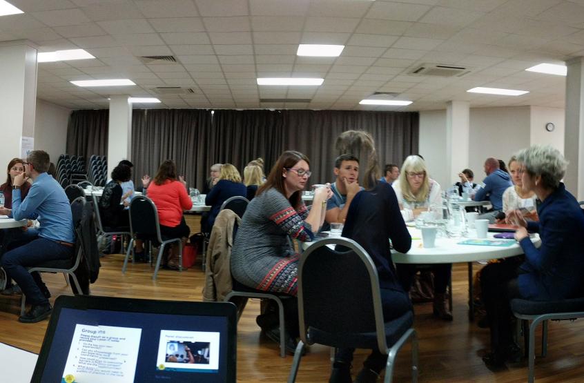 A crowded room of people sat at tables from the 2017 AGM in Manchester