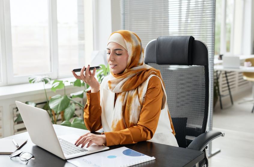 Woman in front of a laptop talking on the phone
